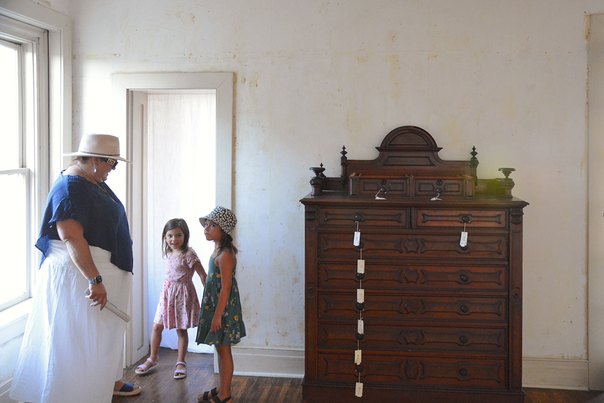 Amy Rowland, 6th generation descendent of John A. Rowland, and her grand-nieces besides Evan Curtis Charles Hall's collaborative artwork On Rancho La Puente, We Dreamed That We Were (2024). 